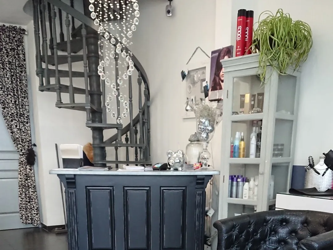 L'accueil du salon Julie Coiffure, comptoir ardoise et escalier en fer forgé — coiffeur à Calais
