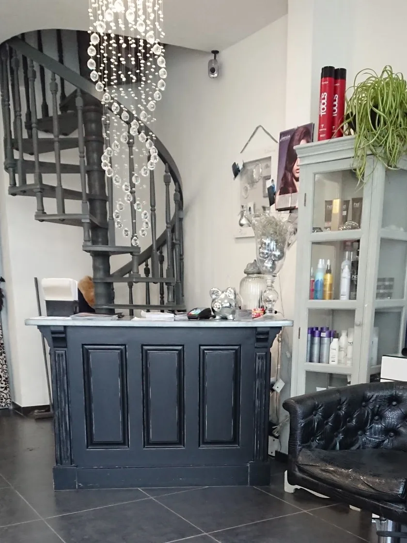 Comptoir d'accueil et escalier en colimaçon du salon Julie Coiffure — coiffeur à Calais